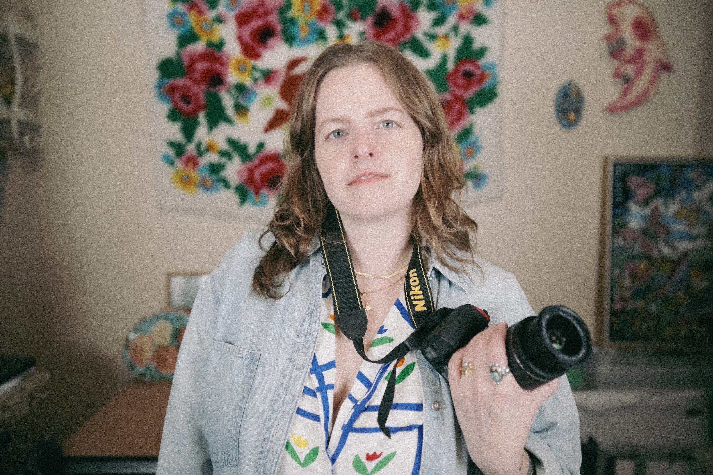 Laura Kay Keeling, artist, holding a camera and looking directly into the lens.