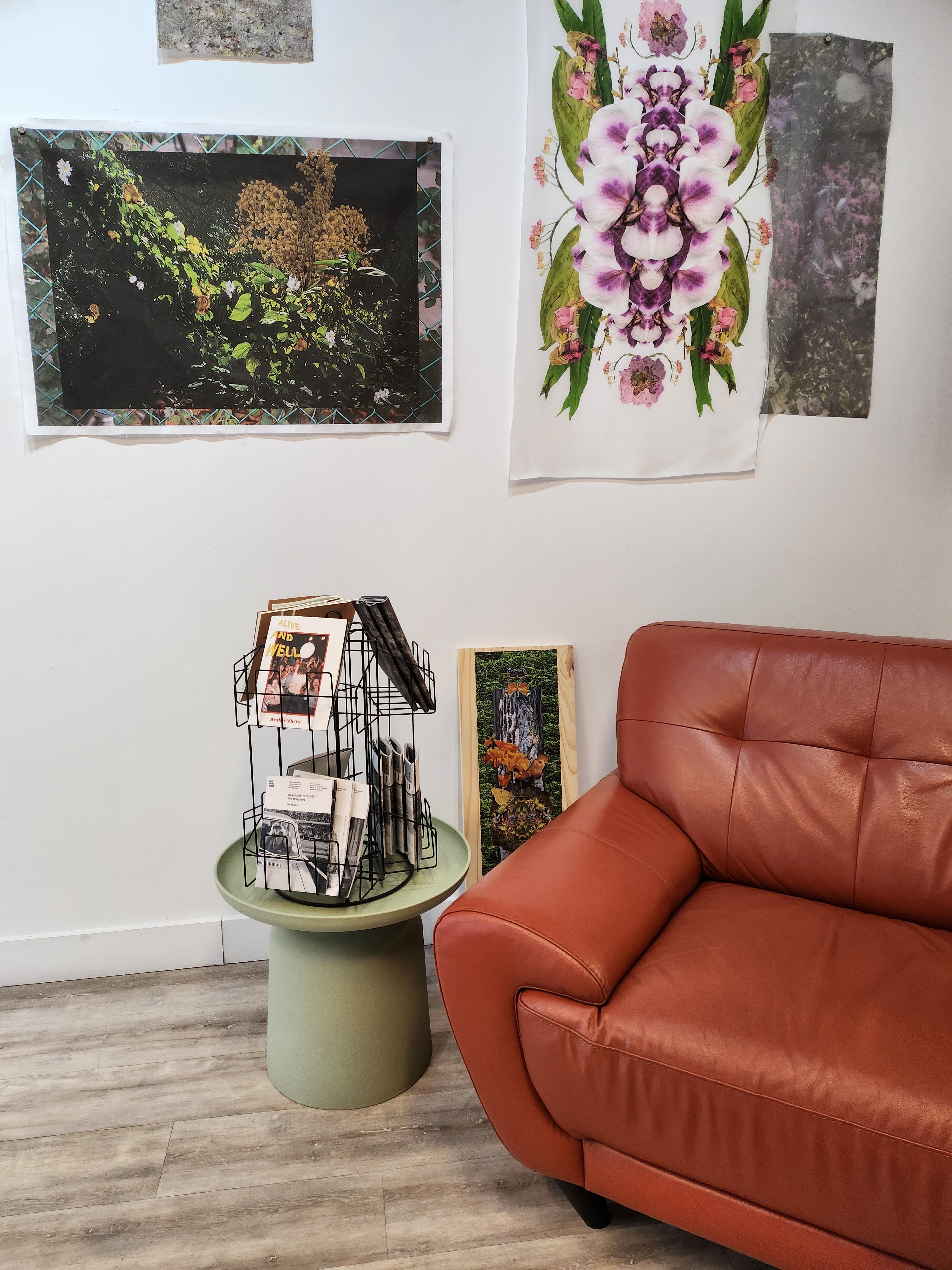 An orange chair sits in front of artwork pinned to the wall.