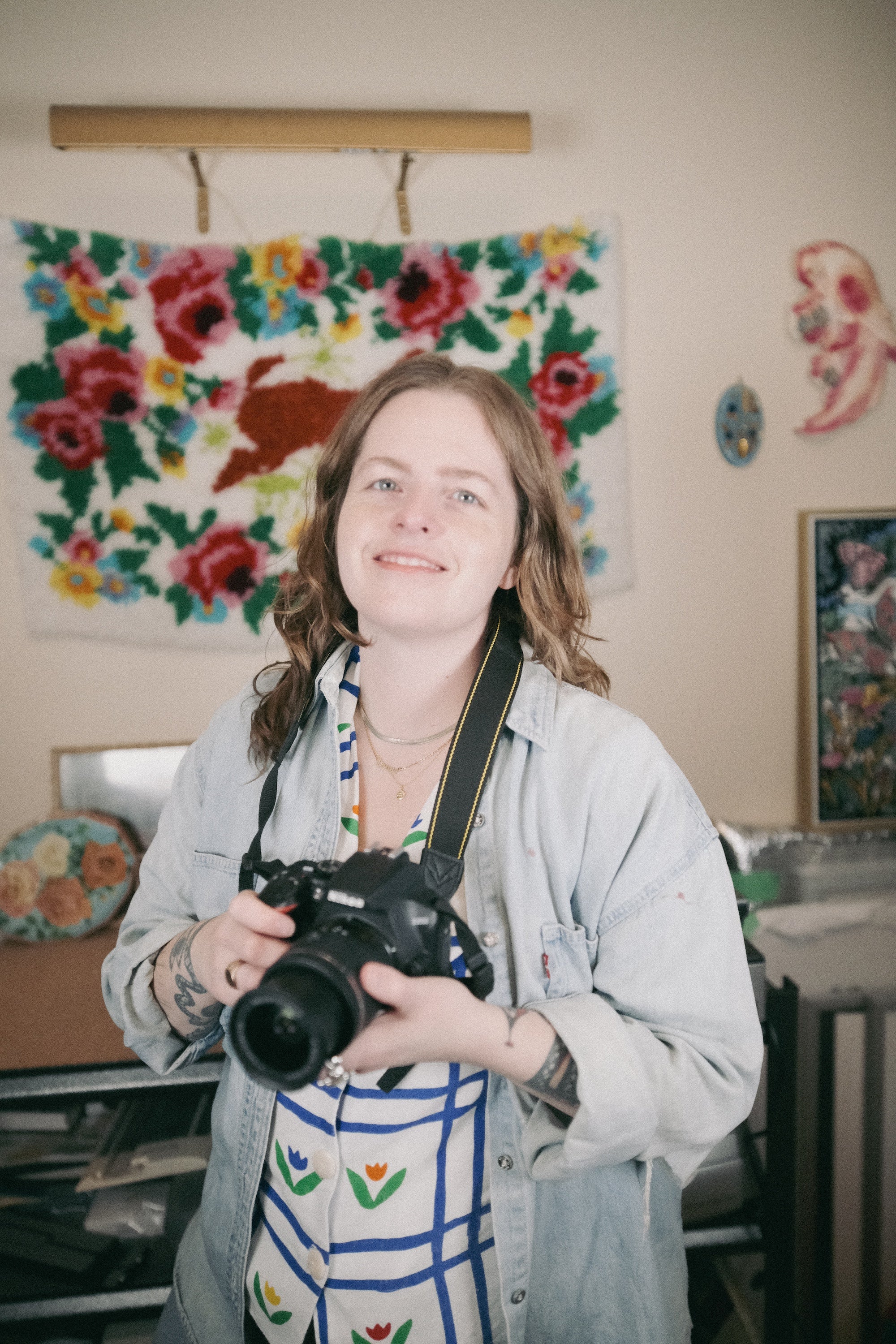 Laura Kay Keeling, artist, holding a camera and looking directly into the lens.